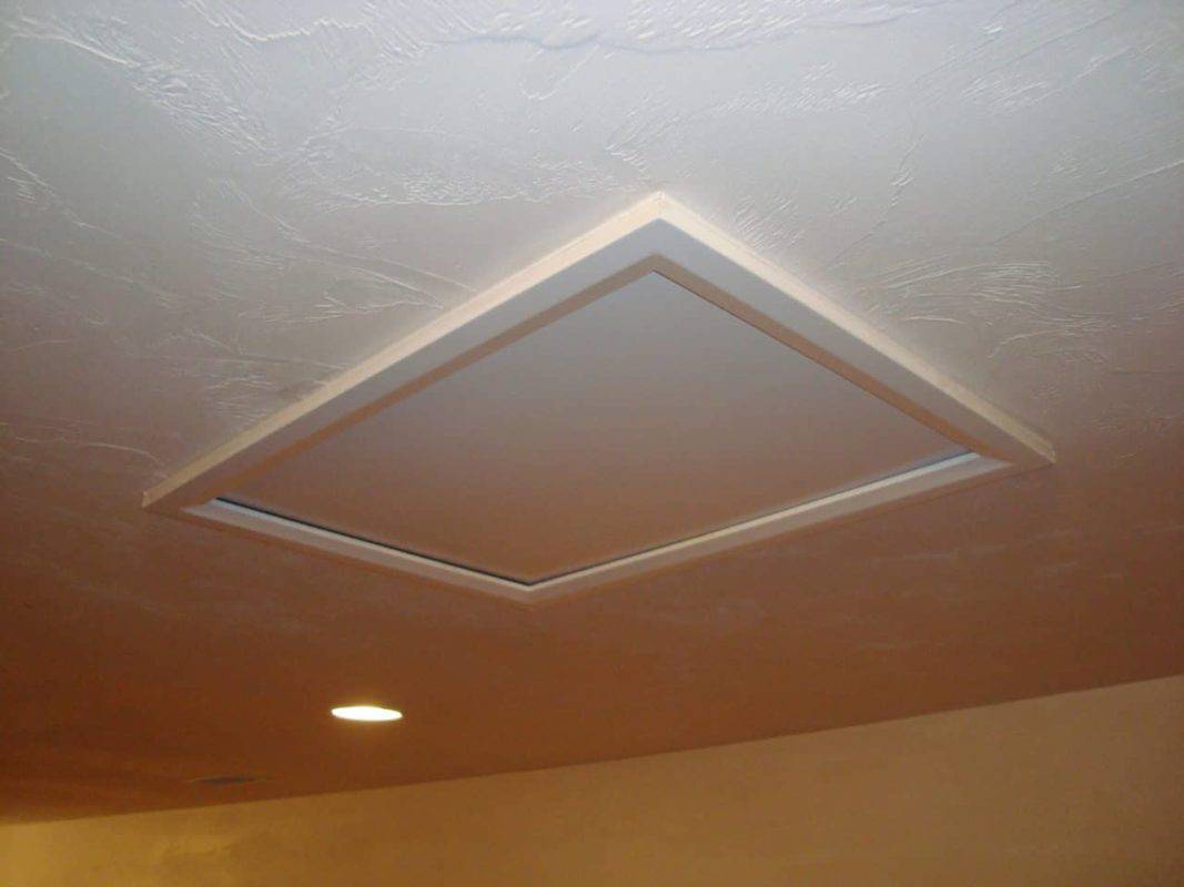Recessed rectangular ceiling light fixture with LED trim in drywall ceiling.