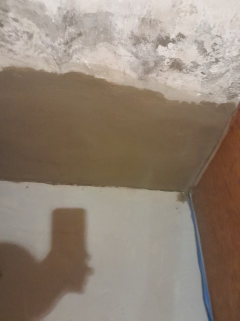 Basement ceiling with patched concrete and drywall tape during renovation work